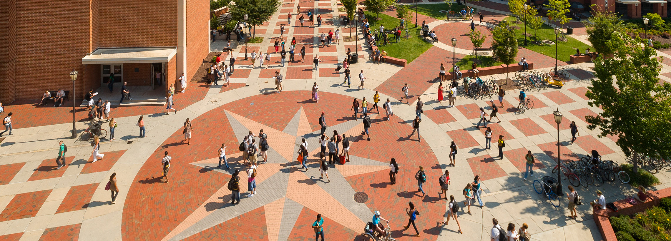Students walking on campus near the compass